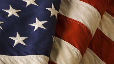 Close-up of a weathered, old American flag of the United States of America, used as a patriotic decoration on Fourth of July (Independence Day), Memorial Day, Veterans Day, and other national holidays.
