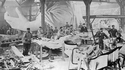 Workmen constructing the Statue of Liberty in Frederic Auguste Bartholdi's Parisian warehouse workshop; first model; left hand and quarter-sized head. Photo by Albert Fernique, ca. 1882-83.
