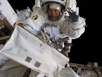 October 18, 2019. NASA astronaut Jessica Meir waves at the camera during a spacewalk with fellow NASA astronaut Christina Koch (out of frame). They ventured into the vacuum of space for seven hours and 17 minutes to swap a failed battery charge-discharge unit (BCDU) with a spare during the first all-woman spacewalk. The BCDU regulates the charge to the batteries that collect and distribute solar power to the orbiting lab's systems.
